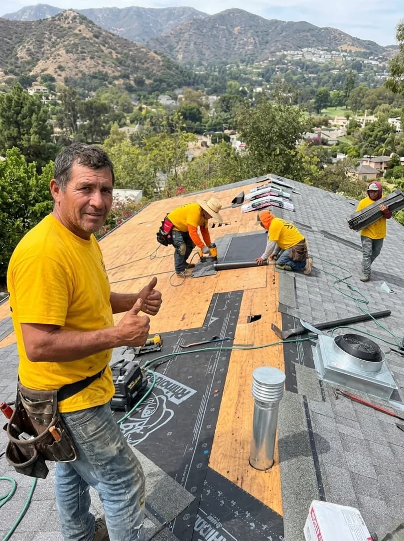 Wild Oak Construction crew member giving a thumbs up on a completed roof